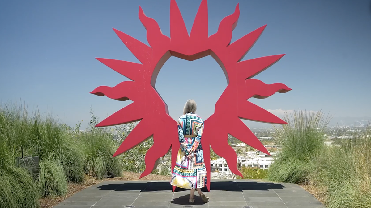 Woman looking through Spirit Mark statue